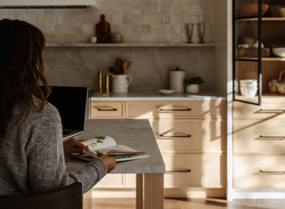 Woman looking at a magazine in a beautiful kitchen