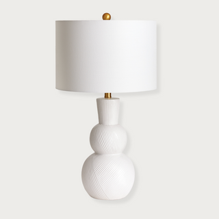 In a classic clean white ceramic with hand carved markings along the body, this lamp is made for the traditional setting. A generally scaled white linen shade &amp; simple brass finial finish off the look.Max wattage: 100W;-Socket: E26
Third & Main, Home Decor, Lighting, Table Lamp, Side Table Lamp, Contemporary Lighting, Luxury Home, Luxury Lighting, Hand Carved Detail