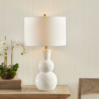 In a classic clean white ceramic with hand carved markings along the body, this lamp is made for the traditional setting. A generally scaled white linen shade &amp; simple brass finial finish off the look.Max wattage: 100W;-Socket: E26
Third & Main, Home Decor, Lighting, Table Lamp, Side Table Lamp, Contemporary Lighting, Luxury Home, Luxury Lighting, Hand Carved Detail