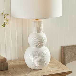 In a classic clean white ceramic with hand carved markings along the body, this lamp is made for the traditional setting. A generally scaled white linen shade &amp; simple brass finial finish off the look.Max wattage: 100W;-Socket: E26
Third & Main, Home Decor, Lighting, Table Lamp, Side Table Lamp, Contemporary Lighting, Luxury Home, Luxury Lighting, Hand Carved Detail